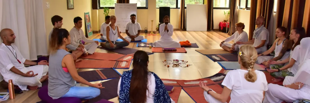 A group of people sitting in a circle on the floor, meditating.